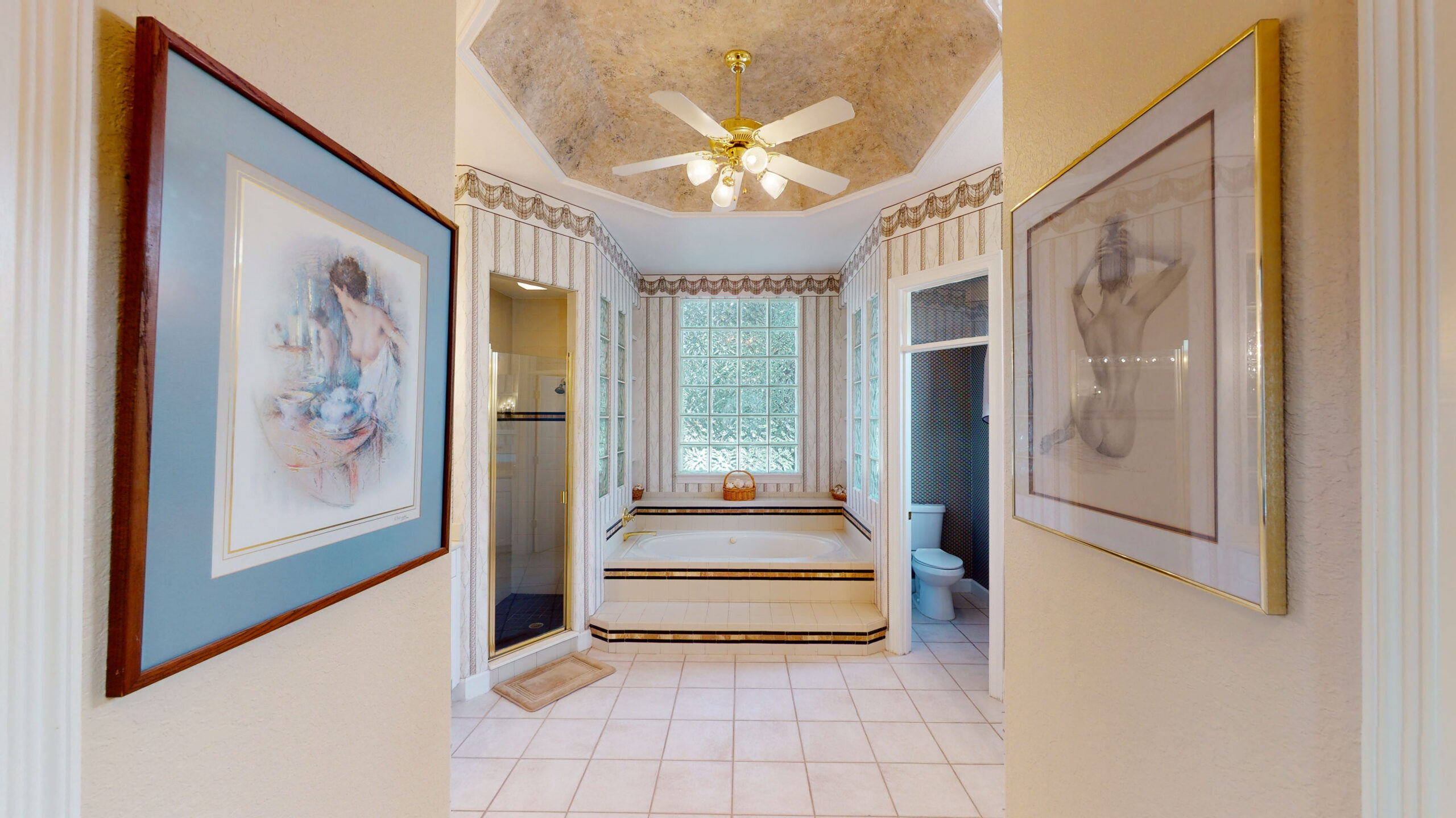 A white bathroom with framed drawings