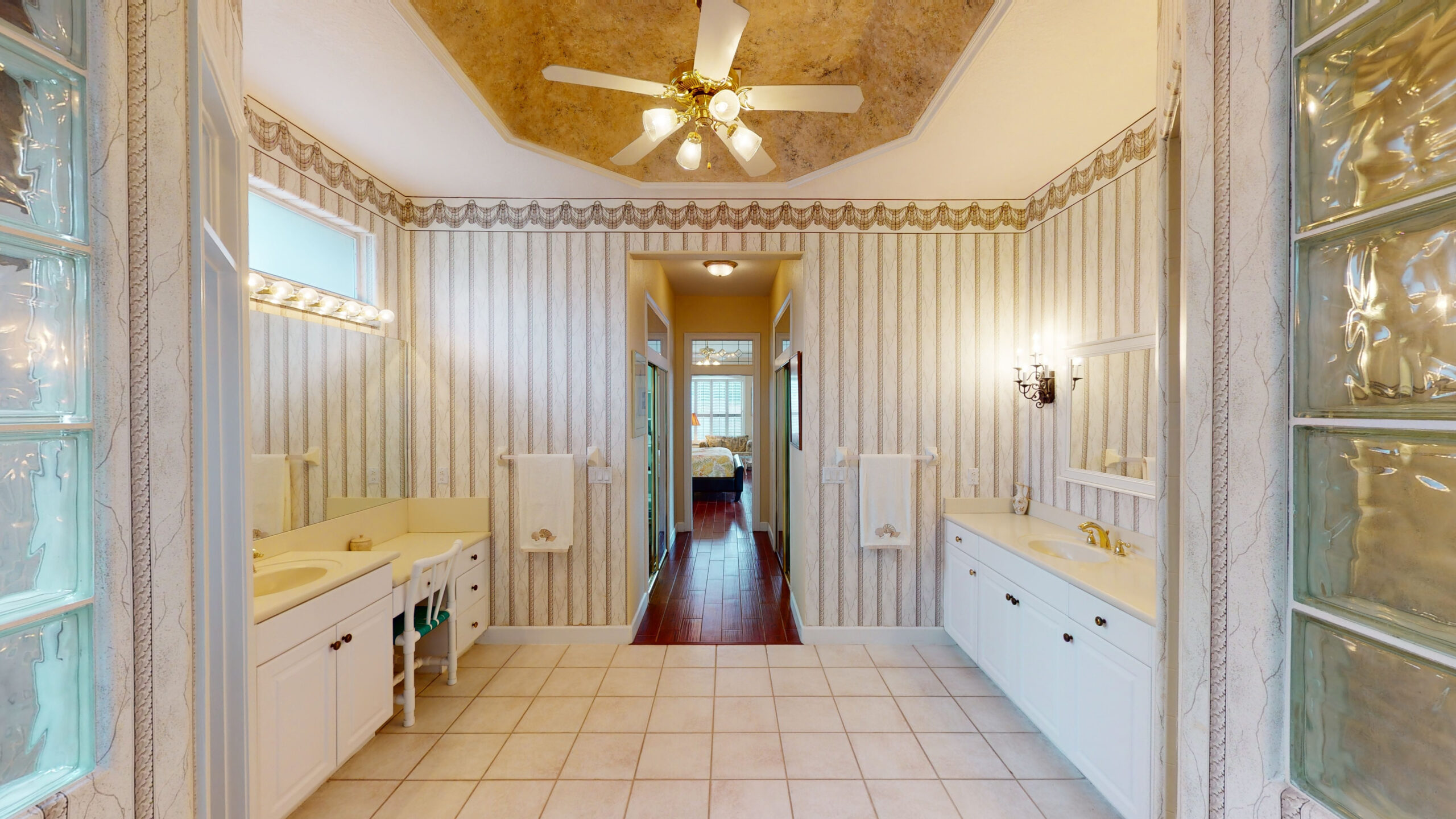 A white bathroom with a fancy ceiling fan