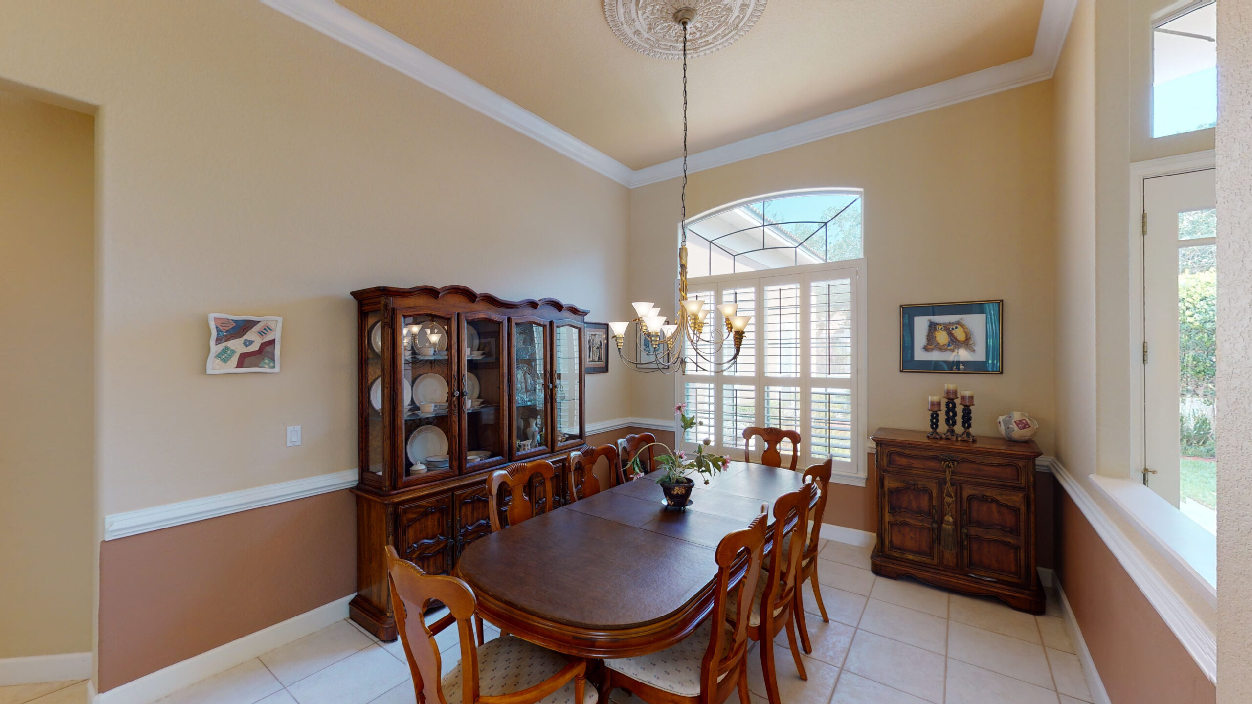 A dining area with wooden cabinets, chairs, and tables