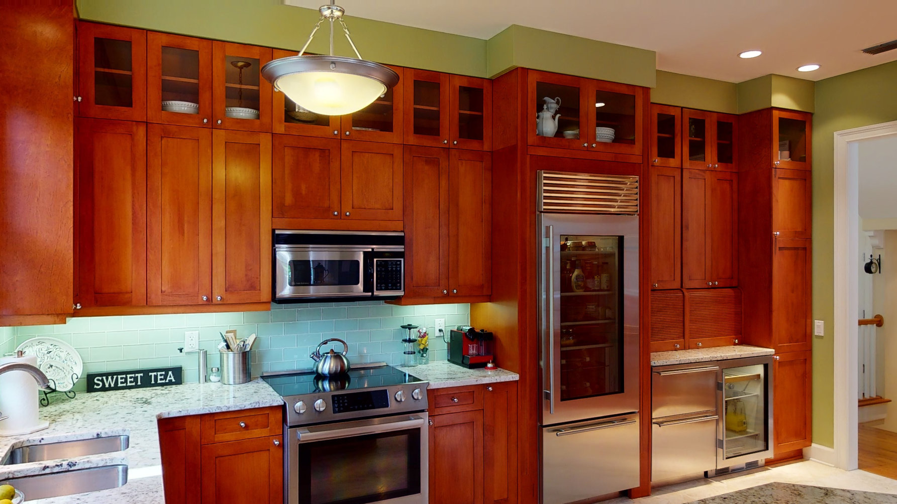 A kitchen with wooden cabinets and metallic appliances