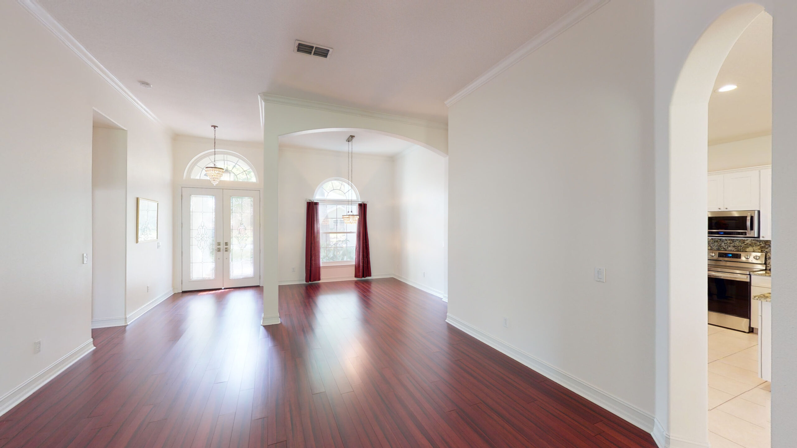 A bare white hallway with mahogany flooring